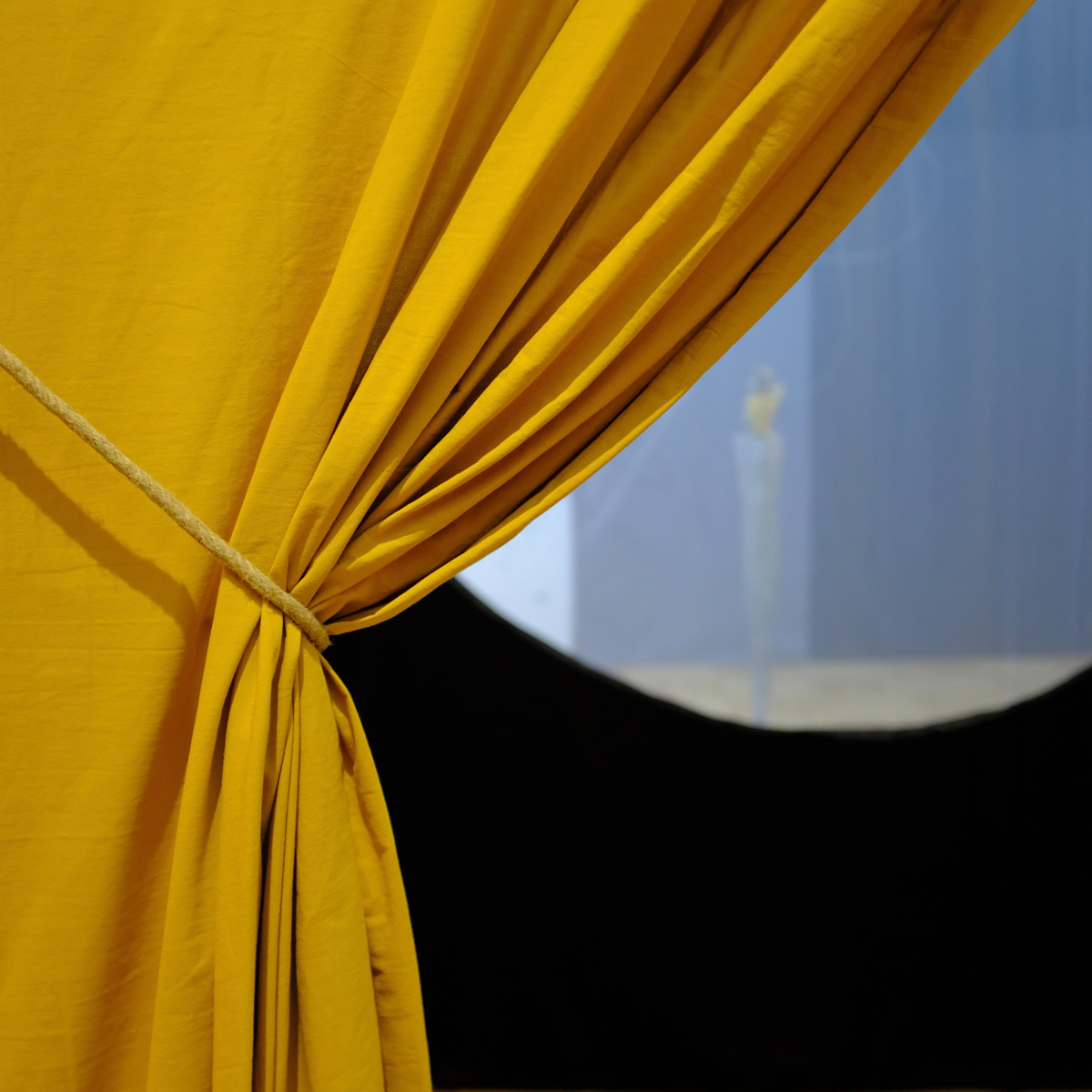 a yellow curtain being pulled to the side